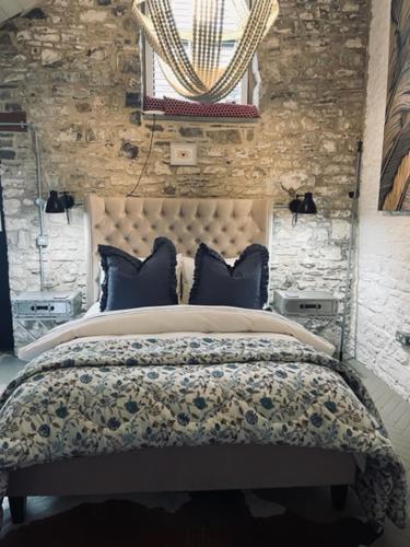 a bedroom with a large bed with blue pillows at Gardener's Cwtch, Llwynhelig Manor in Llandeilo