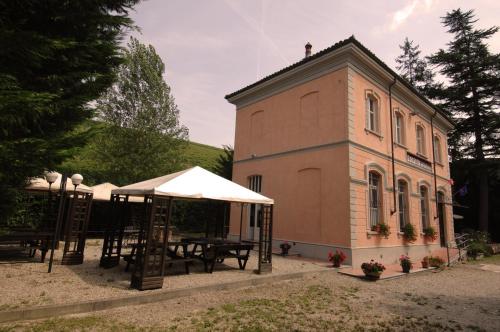 a building with a table and an umbrella in front of it at Locanda Del Barbaresco in Alba
