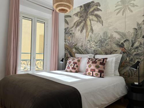 una camera da letto con un grande letto e carta da parati tropicale di LE BAIN DE SOLEIL luxury 2 bedrooms Cannes centre a Cannes