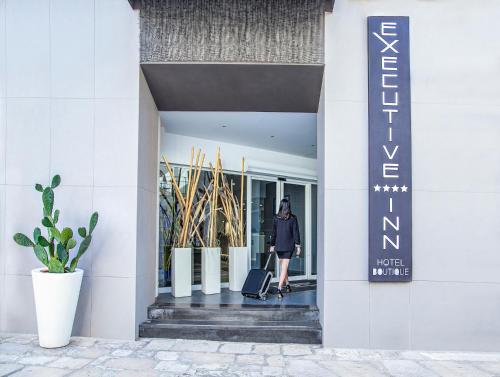 una mujer entrando en un edificio con una maleta en Executive Inn Boutique Hotel, en Brindisi