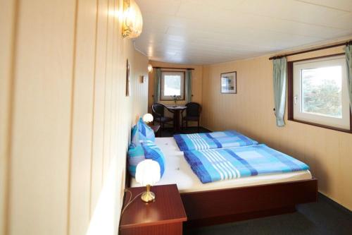 a small bedroom with a bed and a table at Hotelschiff Stinne in Wustrow