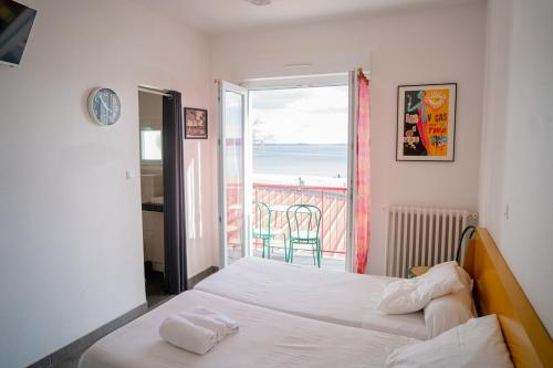 a bedroom with a bed and a view of the ocean at LE MOUTCHICO in Lacanau