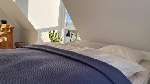 a bed with a blue blanket on top of it at Villa Søholt - Silkeborg Bed and Breakfast in Silkeborg