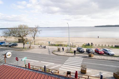 una calle con coches estacionados junto a una playa en LE MOUTCHICO, en Lacanau