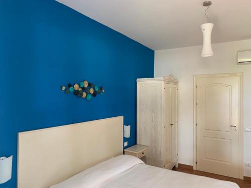 サン・ヴィート・ロ・カーポにあるVilla Ancora Bed & Breakfastの青い壁のベッドルーム1室、ベッド1台が備わります。