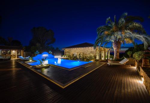 a backyard with a swimming pool at night at Donna Carolina Luxury rooms in Cefalù