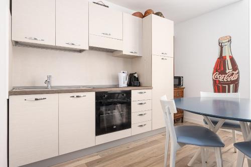 a kitchen with a table and a coke bottle on the wall at Classbnb - 2 comfortable apartments in Monte Carlo in Beausoleil