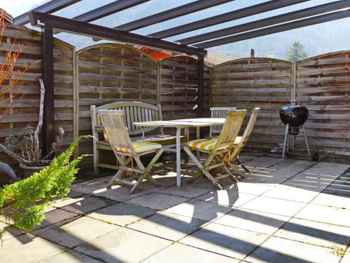 a patio with a table and chairs and a grill at Apartment Carina 4 4 by Interhome in Wilderswil