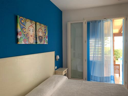 サン・ヴィート・ロ・カーポにあるVilla Ancora B&Bの青い壁のベッドルーム1室(ベッド1台付)