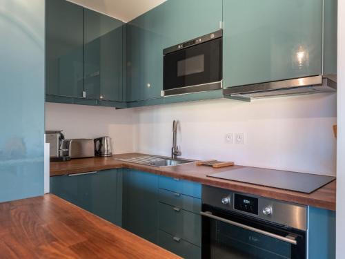 une cuisine avec des armoires bleues et un évier dans l'établissement Apartment Les Lauriers by Interhome, à Lacanau-Océan