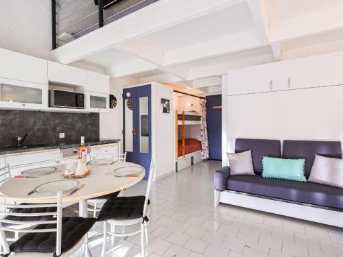 une cuisine et un salon avec une table et un canapé dans l'établissement Apartment Le Florid-11 by Interhome, au Cap d'Agde