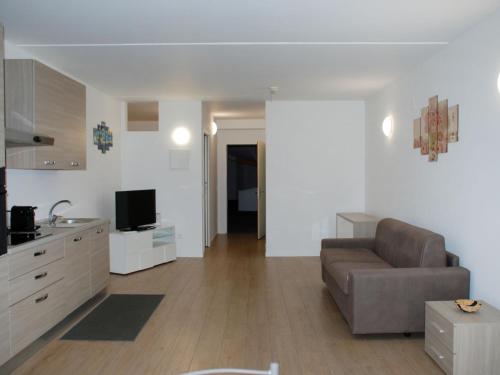 a living room with a couch and a television at Apartment Charming Gardenview App- 102 by Interhome in Bissone