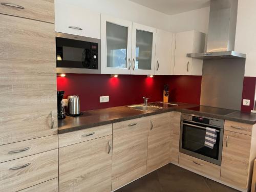uma cozinha com armários de madeira e um lavatório em Apartment Fankhauser by Interhome em Piesendorf