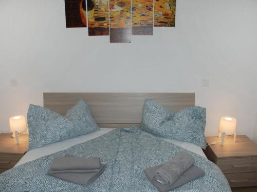 a bedroom with a bed with blue pillows at Apartment Charming Gardenview App- 105 by Interhome in Bissone