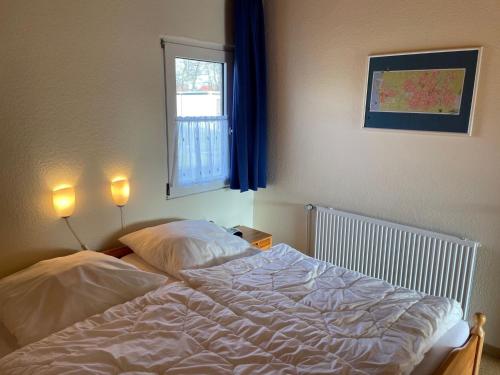 an unmade bed in a bedroom with a window at Holiday Home Kiel by Interhome in Norddeich