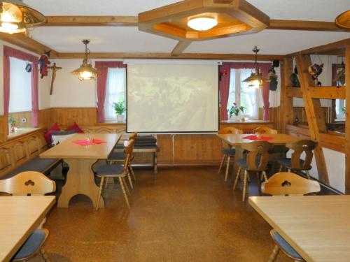 uma sala de aula com mesas e cadeiras e uma tela de projeção em Holiday Home Hexenstüble by Interhome em Simonswald