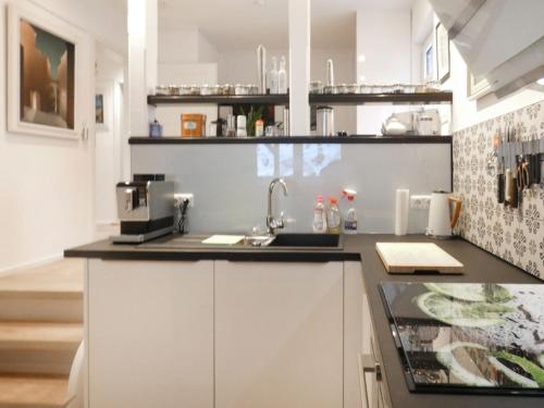 a kitchen with white cabinets and a sink at Holiday Home Grenzenlos by Interhome in Bad Brambach