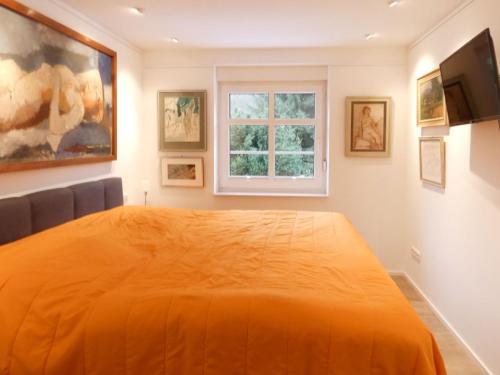 a bedroom with an orange bed and a window at Holiday Home Grenzenlos by Interhome in Bad Brambach