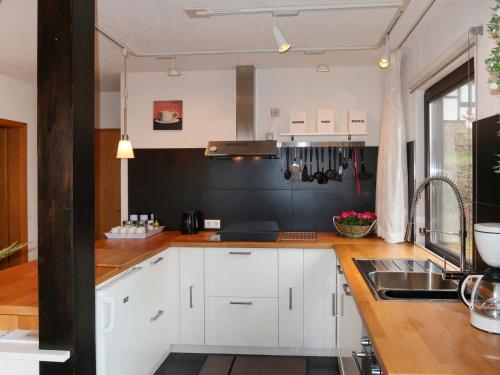 a kitchen with white cabinets and a sink at Apartment Am Sternberg 250 by Interhome in Frankenau