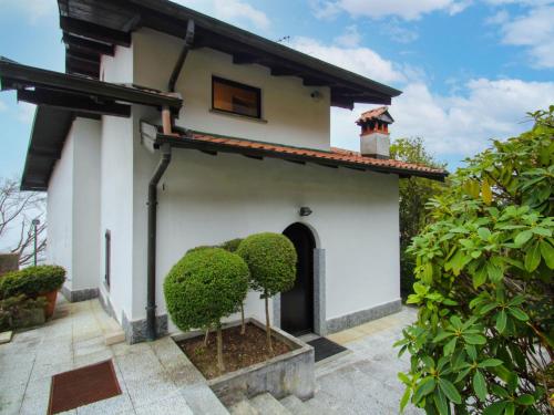 a white house with a tree in the courtyard at Holiday Home Pietro by Interhome in Stresa