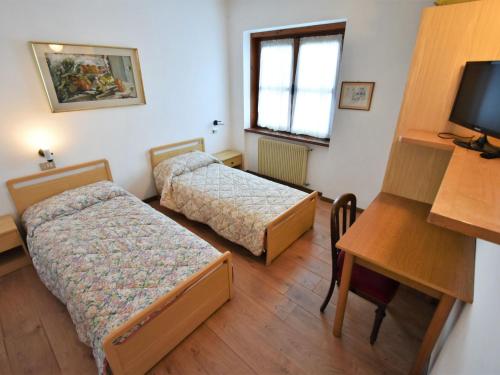 a small room with two beds and a desk at Villa Villa Lucia by Interhome in Pellizzano