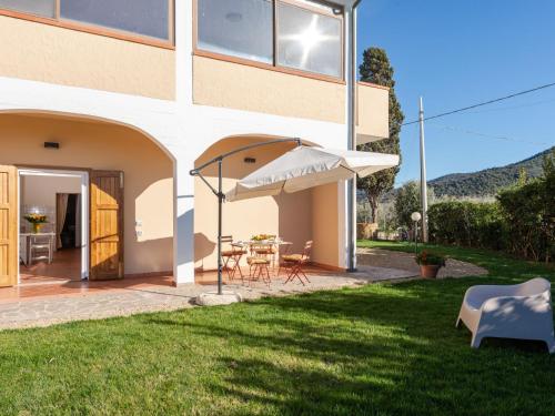 un patio con sombrilla, mesa y sillas en Apartment Antonella by Interhome en Castiglione della Pescaia