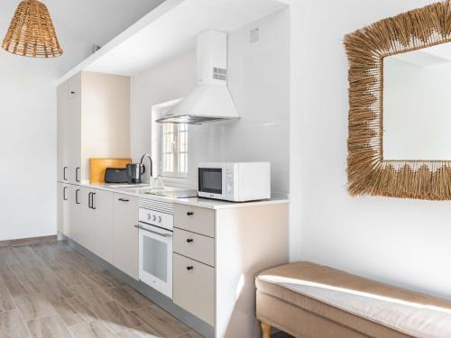 a kitchen with white cabinets and a microwave at Holiday Home Quinta de Santa Emilia 2 by Interhome in São Martinho