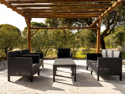 a group of chairs and tables under a pergola at Holiday Home Quinta de Santa Emilia 3 by Interhome in São Martinho