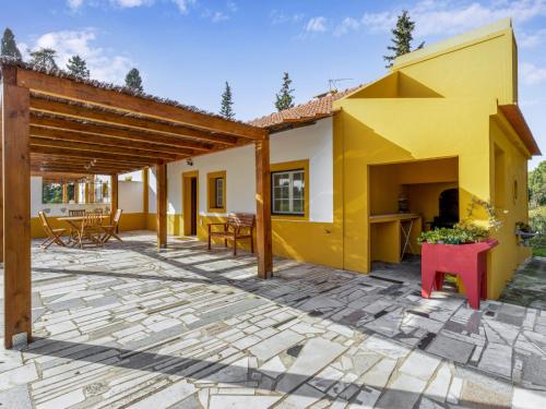a patio with a yellow and white house at Holiday Home Quinta de Santa Emilia 1 by Interhome in São Martinho
