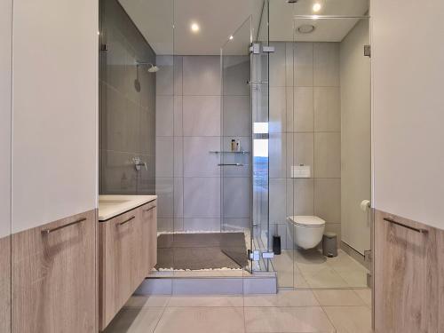 a bathroom with a shower and a toilet at Luxurious Menlyn Maine 1 Bedroom on 12th Floor with Stunning Views & No Load Shedding in Pretoria