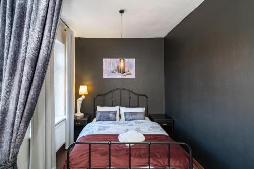 - une chambre avec un lit et une lampe pendant dans l'établissement Retro Studio Old Town Apartment by Domvia, à Kaunas