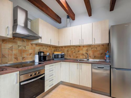 una cocina con armarios de madera y electrodomésticos de acero inoxidable en Holiday Home Vista del Mar 2 by Interhome, en La Oliva