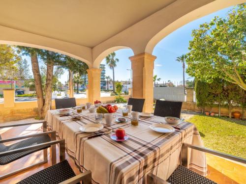 un lungo tavolo su un portico con sedie e cibo sopra di Holiday Home Can Xiroia by Interhome a Alcudia