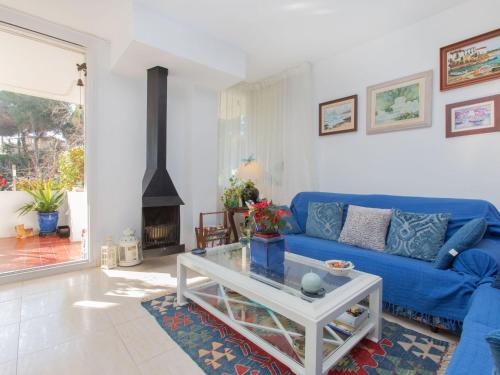 sala de estar con sofá azul y chimenea en Apartment Cala Bona by Interhome, en Blanes
