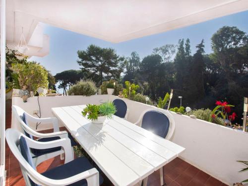 - Balcón con mesa blanca y sillas en Apartment Cala Bona by Interhome, en Blanes