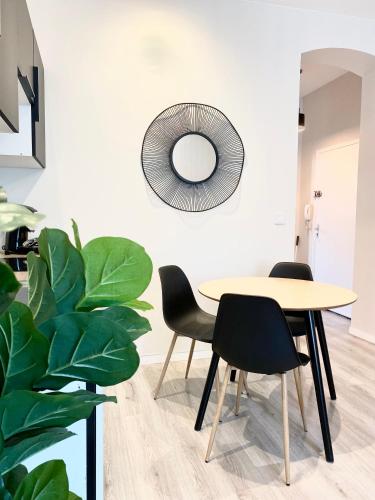 une salle à manger avec une table, des chaises et un miroir dans l'établissement La note dorée, à Vichy
