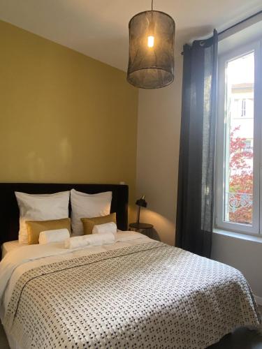 une chambre avec un grand lit avec une fenêtre dans l'établissement La note dorée, à Vichy
