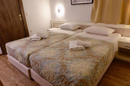 two beds in a hotel room with towels on them at Modern Cycladic Sea View House in Ornos
