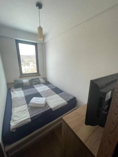 a small bedroom with a bed and a television at Vidik Kopaonik in Kopaonik