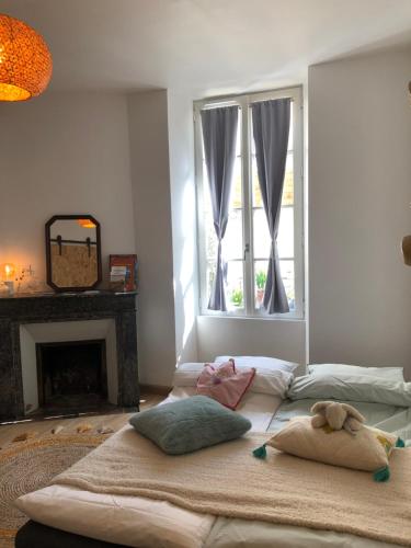 een kamer met 2 bedden met kussens en een raam bij Hôtes de Maïa Chambre d'hôtes in Moret-sur-Loing
