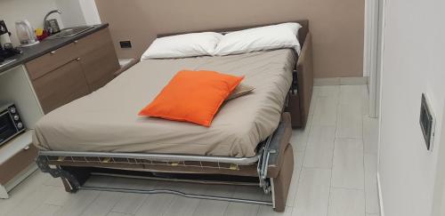 un cuscino arancione su un letto in una stanza di Napoli Capitale a Napoli