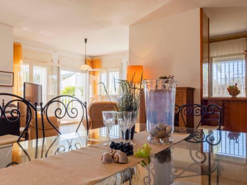 a living room with a glass table with a vase on it at Holiday Home Arenal by Interhome in L'Ampolla