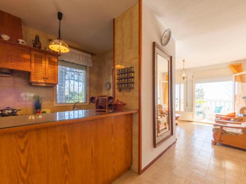 a kitchen with wooden cabinets and a counter top at Holiday Home Arenal by Interhome in L'Ampolla