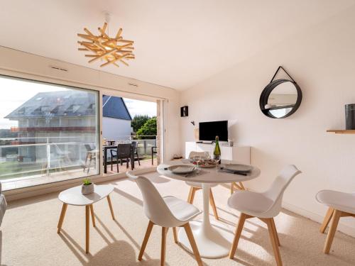 a living room with a table and chairs and a large window at Apartment Le Yacht Club by Interhome in Quiberon