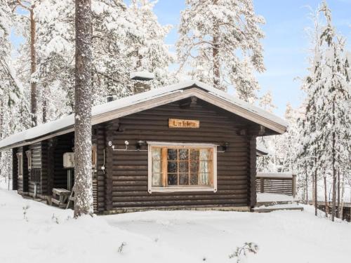 une cabane en rondins dans la neige avec un panneau. dans l'établissement Holiday Home Lakka by Interhome, à Salla