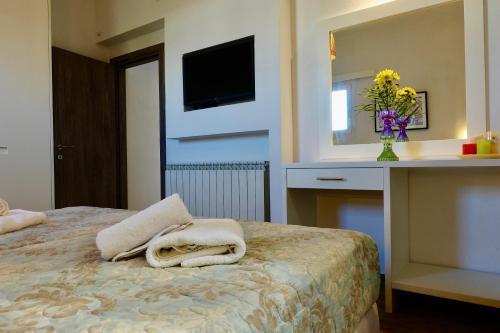 a bedroom with a bed with a desk and a mirror at Modern Cycladic Sea View House in Ornos