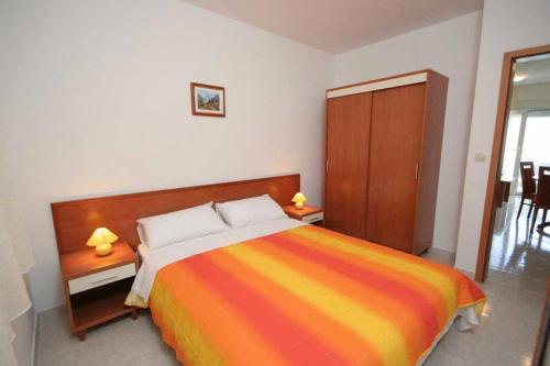 a bedroom with a bed with a colorful striped blanket at Apartments Villa Bayview in Trogir