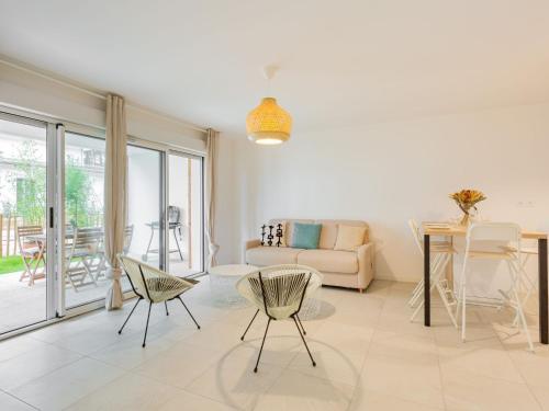 un salon avec un canapé, une table et des chaises dans l'établissement Apartment Dune Blanche-2 by Interhome, à Seignosse