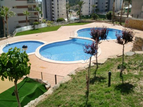 una piscina in mezzo a un cortile alberato di Apartment Torre Mestral by Interhome a Cala de Finestrat