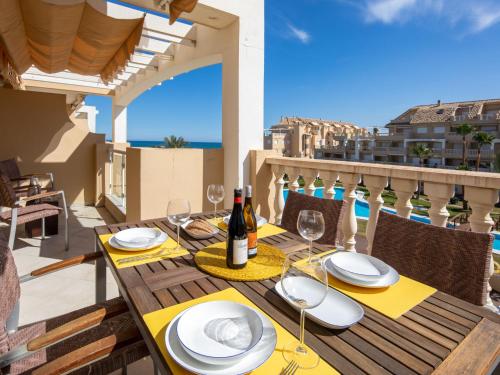 a table with a bottle of wine and glasses on a balcony at Apartamento Tamarindo - Ubicación Premium Frente a la Playa con Piscina in Denia